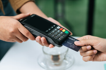 Young businesswoman paying order having contactless payment with cardit card