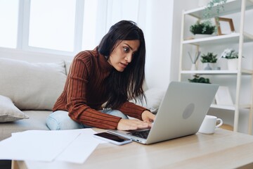 Sad freelance woman typing on laptop and working online from home