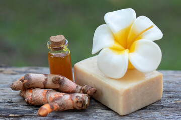 Turmeric, essential oil,bar soap and flower candle on wooden background. spa concept.