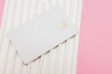 White credit or debit card with chip on the wavy white stone surface