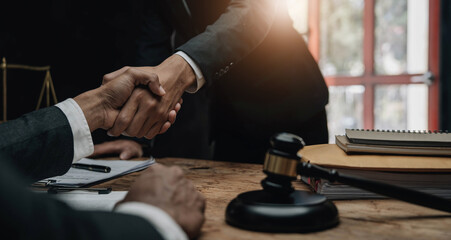 Businessman shaking hands to seal a deal with his partner lawyers or attorneys discussing a contract agreement.