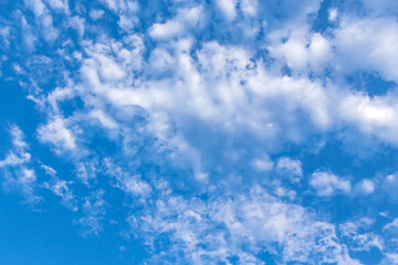 Clouds in the blue sky. Natural sky background texture, beautiful color. Peaceful blue sky with light clouds. The free form beauty of clouds and sky is perfect for background, backdrop and wallpaper.