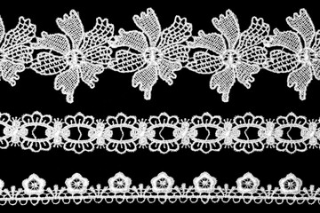 White lace with flowers on black background horizontally