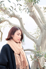 ベージュのマフラーを巻いた女性｜縦位置