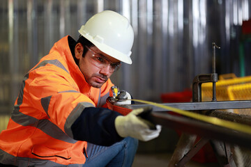 Technicians are using measuring tape to checking the accuracy of the steel structure after assembly before delivery.	