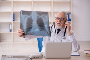 Old male doctor radiologist working in the clinic