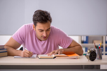 Young male student preparing for exams in time management concep