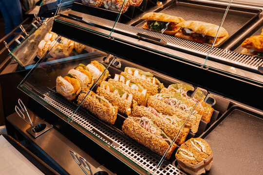 An assortment of sandwiches with various fillings are sold in the window of a store or supermarket. Snacks and fast food concept