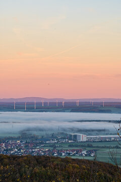 Panorama-Ausblick vom Aussichtsturm auf der Berggipfel Zabelstein bei Hundelshausen im Steigerwald, Blick &uuml;ber das Maintal nach Schweinfurt und Gerolzhofen bei Sonnenaufgang und Nebelschwaden