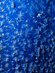 White snowflakes on a blue metal sheet.