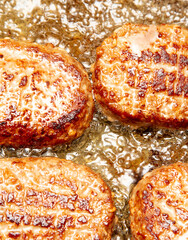 Cutlets are fried in oil in a frying pan.