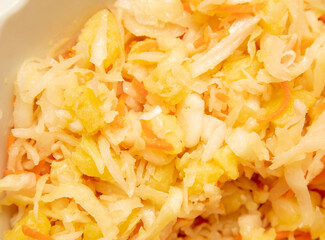 Cabbage salad with potatoes and onions as a background.