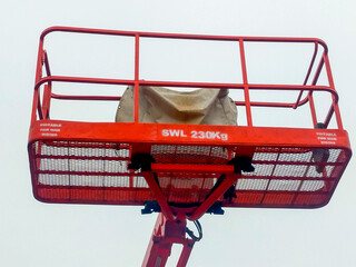 Orange boom lift platform with safety working weight 230 kg.