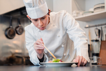 料理の盛り付けをする男性シェフ