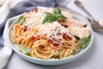 Delicious pasta with tomato sauce, chicken and parmesan cheese on white table, closeup