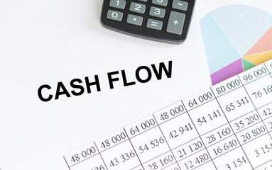 CASH FLOW text on notepad next to calculator and reports, business concept