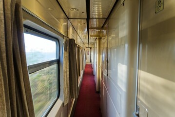 Inside of a train with a red carpet and rooms