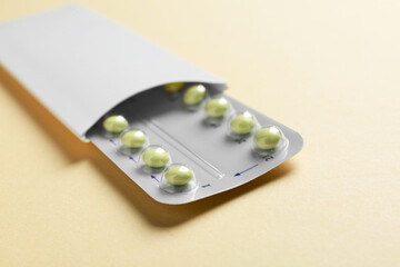 Birth control pills on beige background, closeup