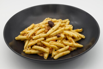 Italian Maccheroni al pettine pasta in a black dish.
