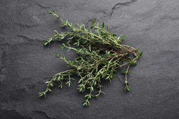 Aromatic fresh thyme on black table, top view