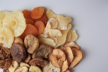 Pile of different dried fruits on white background, top view