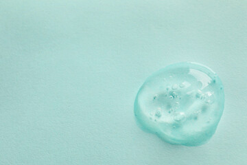 Sample of face gel on light blue background, top view. Space for text