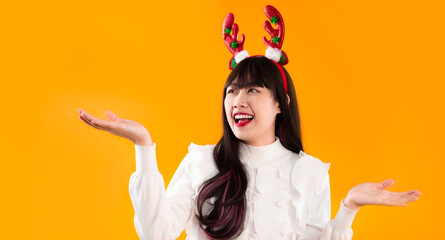 Merry Christmas theme, young asian beautiful woman in white blouse wearing reindeer horns headband...