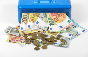 euro bills and coins lying on table and sticking out of blue cash box