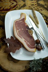 Dried bacon on a plate.  Dried pork steak. Dried pork meat. Typical Bulgarian famous dried pork meat produced in Elena's region.