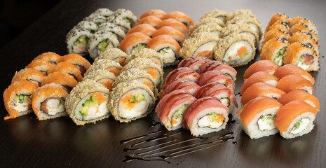Big Sushi set with fresh ingredients on black background. Sushi menu. Japanese food