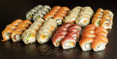 Big Rainbow Sushi set with fresh ingredients on black background. Sushi menu. Japanese food