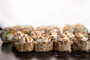Set hot sushi rolls fried decorated cream cheese. Assortment of delicious tempura and baked sushi maki with salmon. Sushi volcano on white background