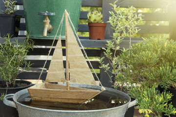 Dreams of travel! Big journeys begin with small steps! Toy sailboat in a water bowl