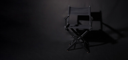 Black director chair isolated on black background.