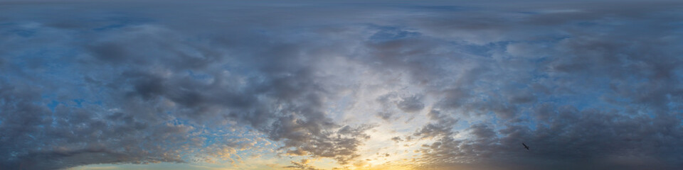 Fototapeta premium Panorama of a dark blue sunset sky with golden Cumulus clouds. Seamless hdr 360 panorama in spherical equiangular format. Full zenith for 3D visualization, sky replacement for aerial drone panoramas.