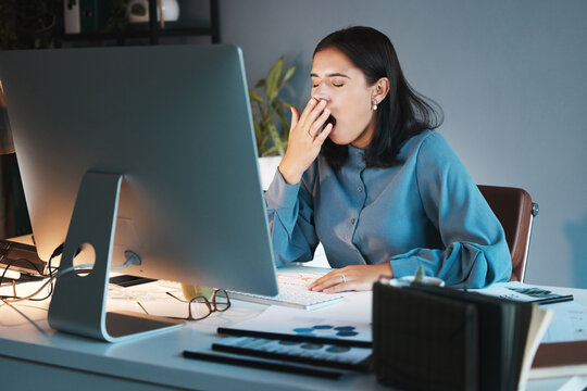 Burnout, tired and business woman yawn in office working on computer for planning, research or marketing idea at night. Overwork, employee or sleepy girl with strain, insomnia or low energy at desk
