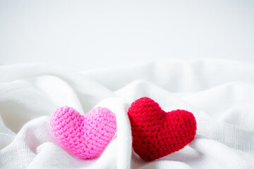 Fototapeta premium Abstract valentine 's day, Red Heart Knitting on white fabric linen texture for graphic design wedding or add text message. Love concept.