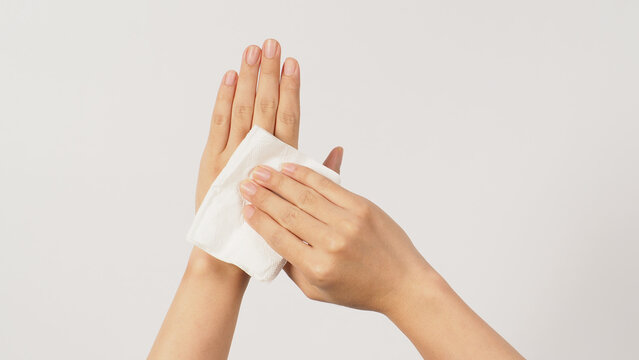 The hand is holding tissue paper and wipes on white background.