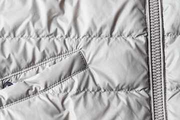 Padded coat in grey color with zipper and pocket. Close up of detail and fabric texture © vasanty