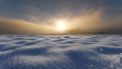 Fototapeta na wymiar Sunset in fog with untouched snowfield in foreground. Low angle winter landscape.
