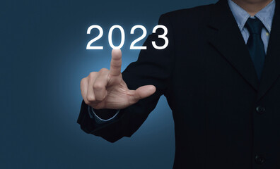 Businessman pressing 2023 letter over light blue wall, Business happy new year 2023 cover concept