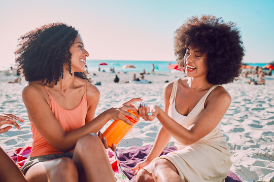 Sunscreen, Beach And Black Woman Friends With Skincare For Summer Sunshine, Outdoor Wellness Or Holiday On Sea Sand. Relax, Product Bottle And Sunblock For Young Women Or People By Ocean Together