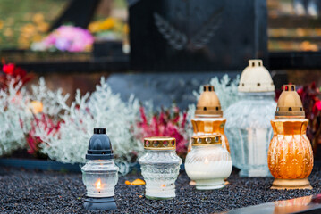 All Saints' Day and burning candles and flowers on the graves.Candles on graves symbolize the memory of the dead on November 1.Catholic cemetery during All Saints' Day.Selective focus.