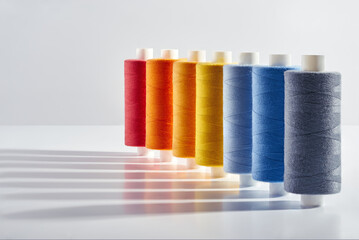 Close up  Spools of sewing threads colorful sort in diagonal wit