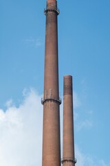Chimney of an old power plant against the blue sky