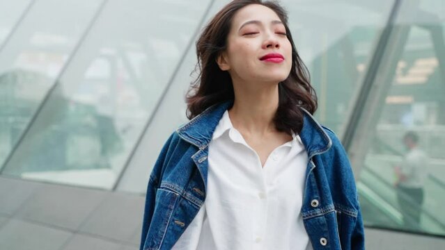 slow motion portrait of young asian woman relax in the urban city charming woman smile at camera in slow motion
