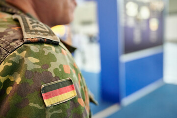 Bundeswehr Soldat in grüner Flecktarn Uniform und Flagge der Bundesrepublik Deutschland auf der...