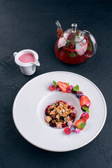 breakfast berries, cherries, raspberries, strawberries, nuts, muesli and yogurt along with pot of fruit tee