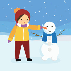The boy attaches a carrot to the snowman's nose