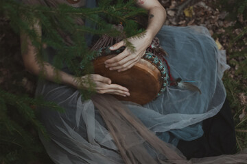 Close up drum playing concept photo. Female musician. Spiritual music. Side view photography with...